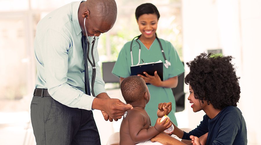 A doctor and nurse checking a young child with his mother